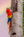 Double Rainbow — two scarlet macaws climbing a palm trunk against a soft pastel rainbow sky, tropical fine art photograph