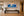 Follow the Current panoramic sea turtle fine art print framed under a picture light above a long console in a refined modern gallery hallway