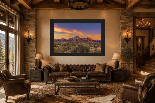 Golden Hour Sedona red rock sunset fine art print framed above a leather chesterfield sofa in a rustic luxury Western ranch great room with timber beams and stone