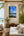 Hermosa Costa Rica coastline fine art print displayed on a tall whitewashed wall in a breezy luxury pool house cabana lounge with teak, rattan, and a turquoise pool view
