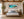 Honu Harmony panoramic Hawaiian green sea turtle and coral reef fine art print framed above the headboard in a serene coastal-modern luxury primary bedroom