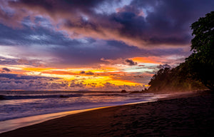 Sunset over a volcanic-sand beach on Costa Rica's Pacific coast