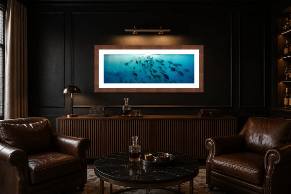 Launch The Torpedoes panoramic school of tuna fine art print framed and picture-lit on a dark paneled wall above a console in a moody luxury cocktail and cigar lounge