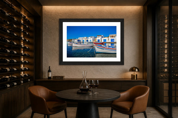 Milos Island Greek fishing village fine art print framed in black on a warm stone wall in a luxury home wine tasting room