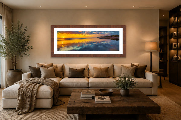 Mirror for the Sun panoramic golden sunset fine art print framed in walnut above a sofa in a warm luxury family den