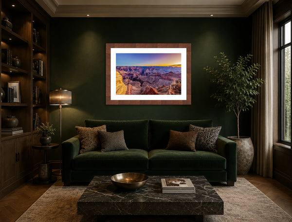Morning Light Grand Canyon sunrise fine art print framed in walnut on a deep emerald green wall above a velvet sofa in a luxury sitting room
