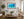 Oahu Wonders underwater dolphin pod fine art print framed in walnut above a white sofa in a bright coastal beach-house living room