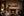 On The Rocks panoramic coastal sunset fine art print framed in black above a stone fireplace mantel in a warm luxury great room