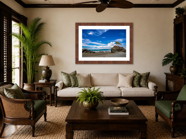 Pacific Paradise tropical beach fine art print framed in walnut above a sofa in a British Colonial tropical living room with palms