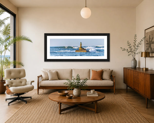 Siren of the Waves panoramic mermaid sculpture seascape fine art print framed in black above a sofa in a warm mid-century modern living room