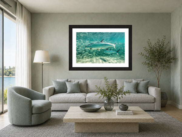 Tarpon Tango silver tarpon underwater print framed above a sofa in a serene sea-glass green living room