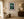 The Elusive Quetzal emerald and crimson bird print framed on a creamy wall in an elegant warm sitting room