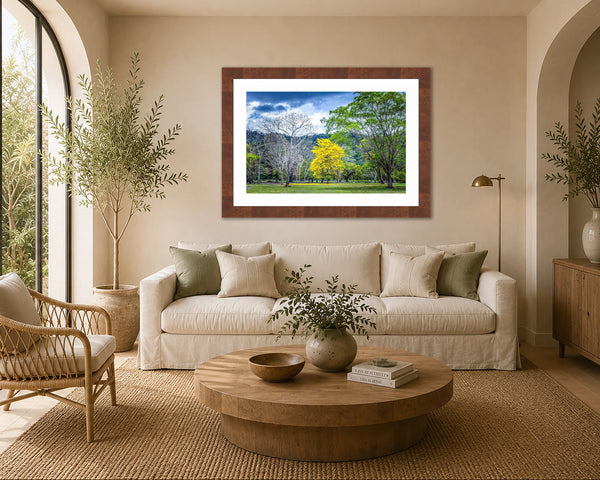 Trees Of Life golden flowering tree print framed above a sofa in a warm organic living room with greenery