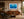Wicked Tuna yellowfin tuna print framed above a cognac leather sofa in a warm mid-century modern living room
